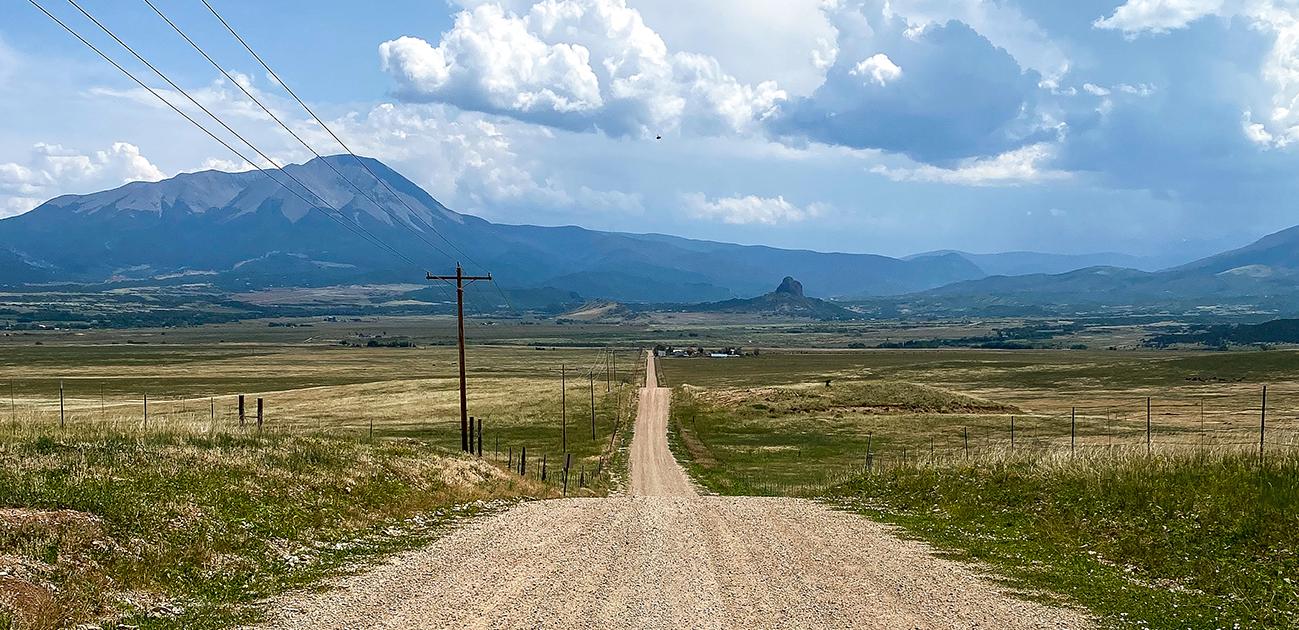 A dirt road heads towards the Spanish Peaks in the Colorado Rocky Mountains